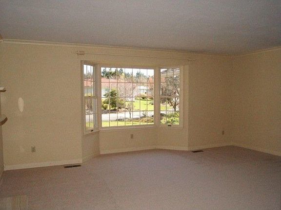 The formal living room has new carpeting, a bay window as well as a fireplace.