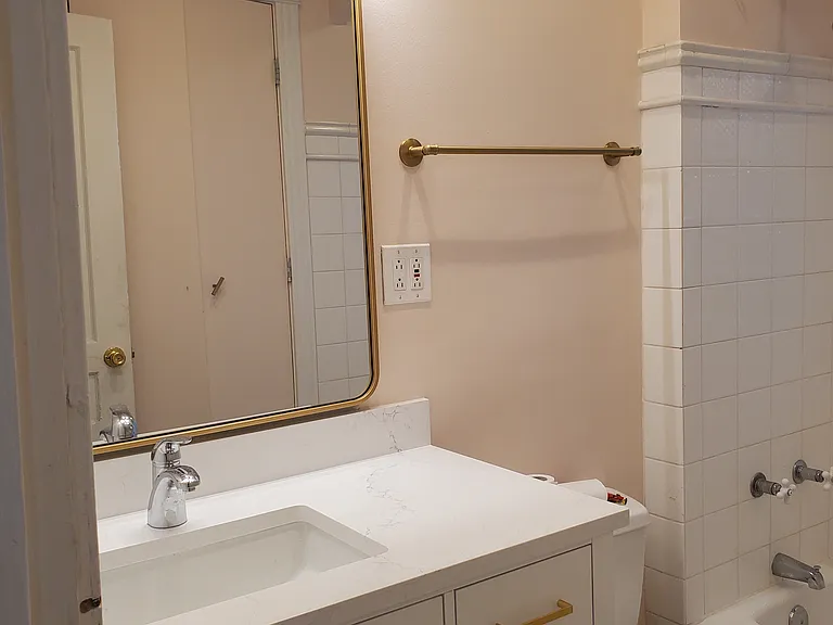 Upgraded bathroom with new vanity, brass accents and large linen closet