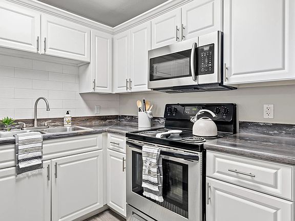 Elegance flows with designer kitchens featuring subway tile backsplash.