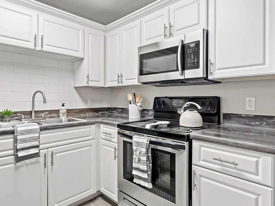 Elegance flows with designer kitchens featuring subway tile backsplash.