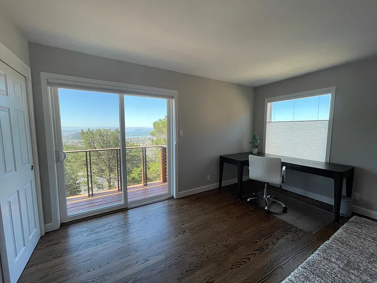 View from Primary Bedroom with Balcony and built in desk with a view