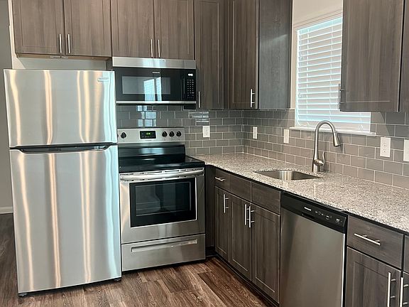 Kitchen with all stainless steel appliances, subway tile backsplash, granite counter tops & plenty of storage.