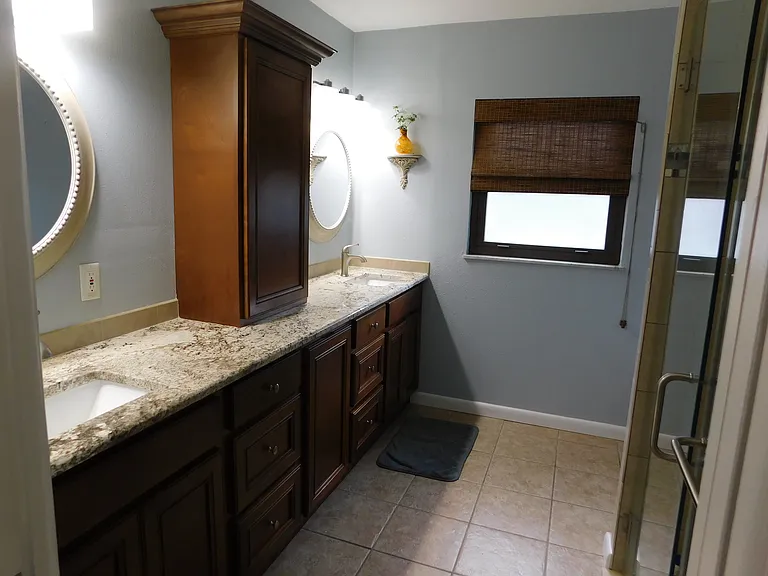 Entering the master bath, we're facing south. Two wash basins with two mirrors are on the left with more than ample cabinetry. To the right is the shower and just beyond that, the toilet.