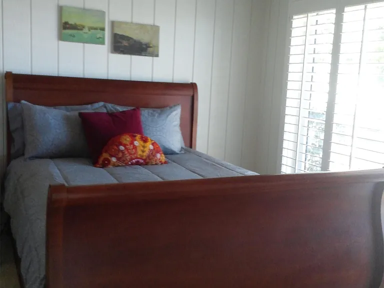 queen bed in master bedroom with harbor view sliding window to deck