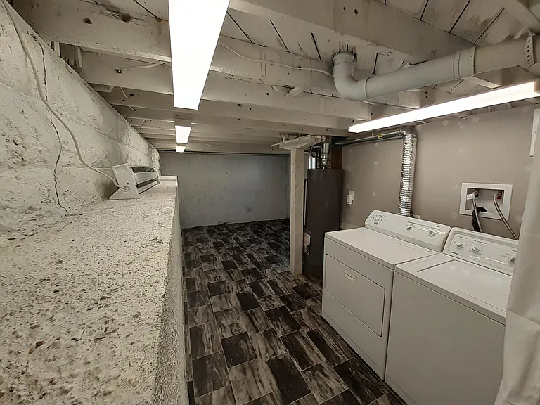 Well-lit basement Laundry room with extra storage.