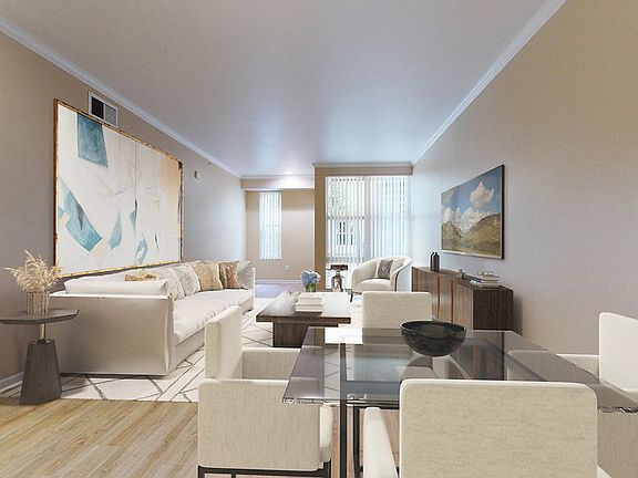 Staged living and dining area with hardwood style flooring.