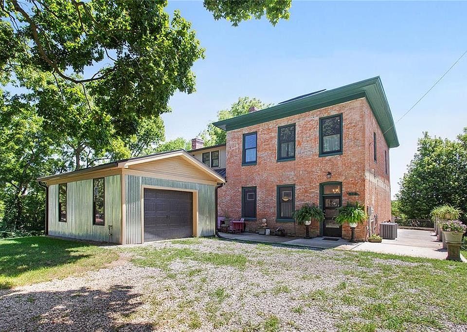 Two story brick antebellum with concrete patio that wraps around for entertainment space or sitting area to enjoy the views; one car garage by the house and second one car garage at lower street level provide plenty of convenience and storage.