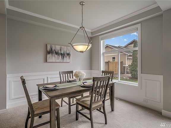 Formal dining room with wainscoting and crown molding. 