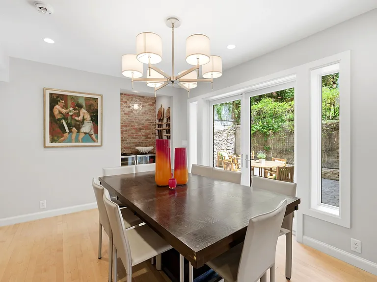 Dining room with built in shelves, back patio entrance and bar nook with exposed brick wall.