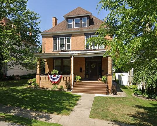 View from tree-lined street, large covered porch, and front yard
