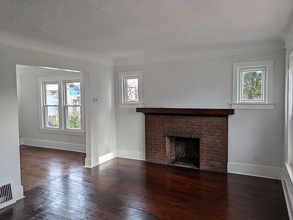 Fireplace and living room with archway to dining room.