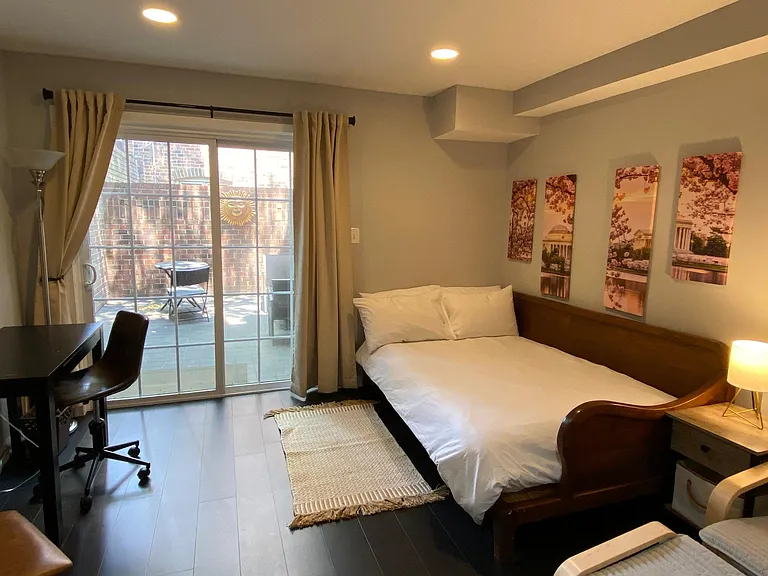 Bedroom #2 with a double sleigh bed, desk, lounge chair and sliding door to patio.