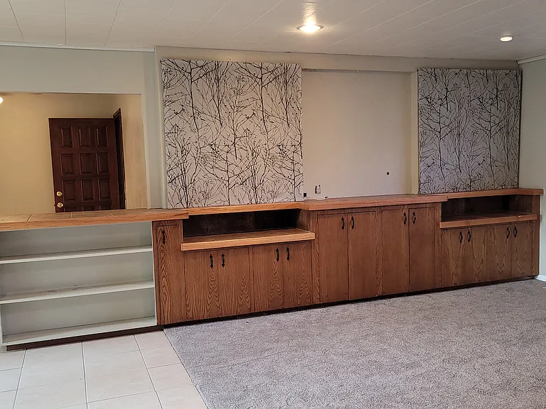 The large back living is a great space for entertaining with built in storage cabinets, and lots of countertop space, tile and new carpet.