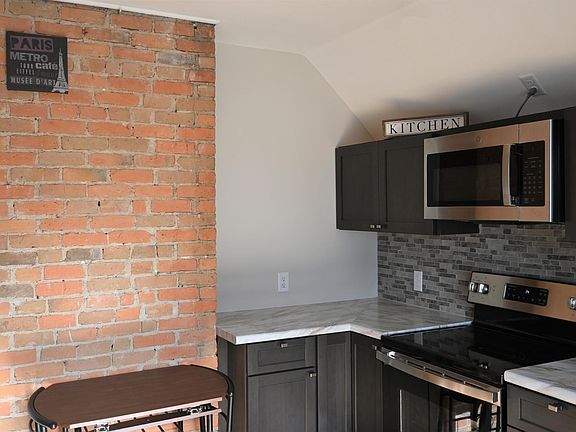 Kitchen back wall with exposed brick feature.