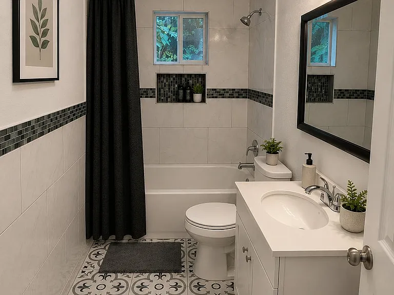 Full bathroom with tiled tub/shower, built-in shampoo niche, patterned tile flooring, and a single-sink vanity with mirror.