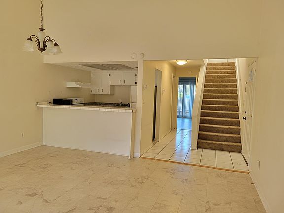 Looking from Living Room back to 1st floor bedroom. Hall to 1st floor bedroom and bathroom, stairs to 2nd bedroom, and front yard in the distance