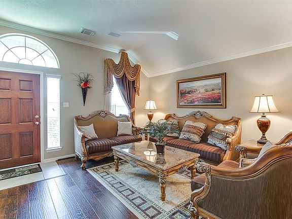 Upon entering this home you are greeted with gleaming hardwoods and high ceilings with crown molding. The living room is spacious and boasts beautiful, custom window treatments.