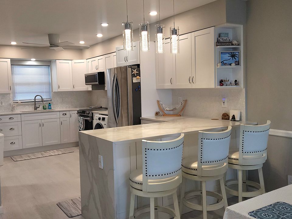 Kitchen with stainless appliances, washing machine, and peninsula.