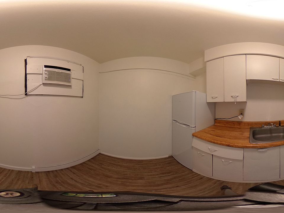 This photo is showing the kitchen space in the studio apartment. You can see the refrigerator included with this unit. There is ample storage and counter space along with a full size sink. The four burner stove includes an oven. It's a great space!