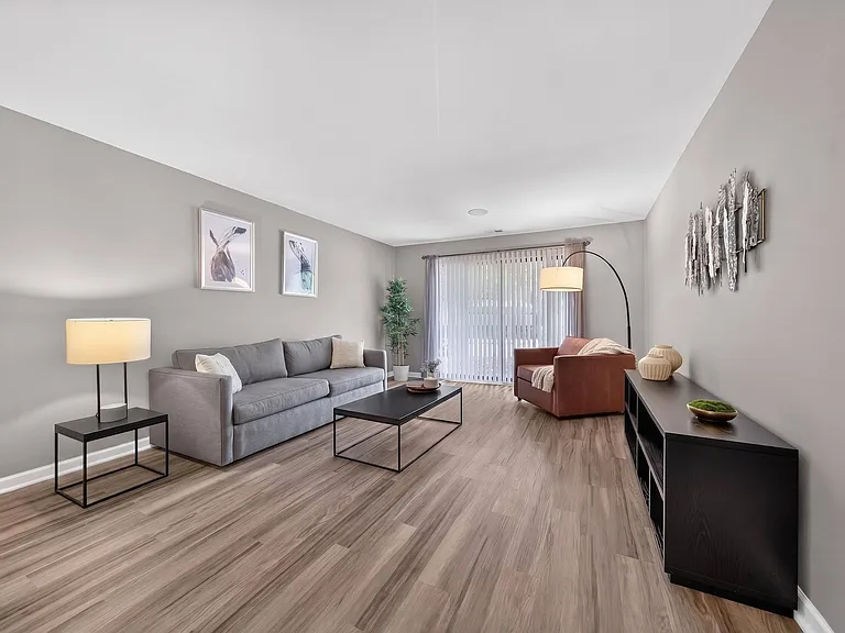 Spacious Living Room with Sliding Glass Door at Lakeside Village Apartments in Clinton Township, MI.