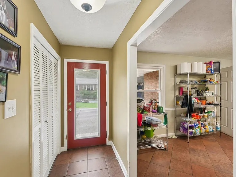 A graceful foyer welcomes you inside with a beautiful door, setting the tone for a home filled with warmth, charm, and quiet storybook elegance.