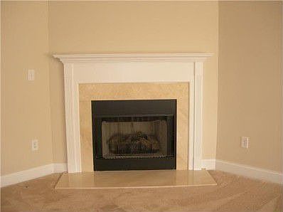 Corner feature gas log fireplace with marble hearth in Great Room