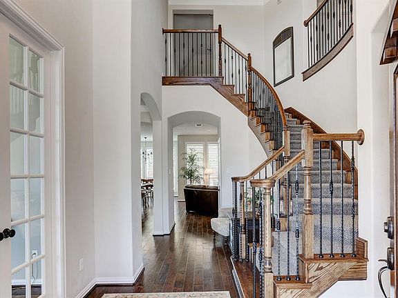 Large entry with gleaming hardwoods, double French doors to the study and a stairway with wood risers and decorative iron railings are just a few of the gorgeous elements that lead you in to this beautiful home and its open floorplan.