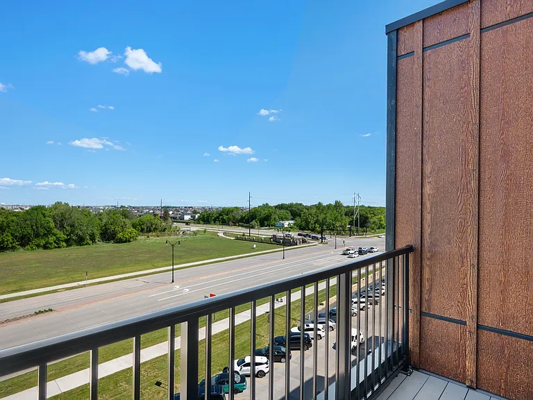 Charming balcony view showcasing a serene green landscape and clear blue sky, perfect for relaxing outdoors. Charming balcony view showcasing a serene green landscape and clear blue sky, perfect for relaxing outdoors.