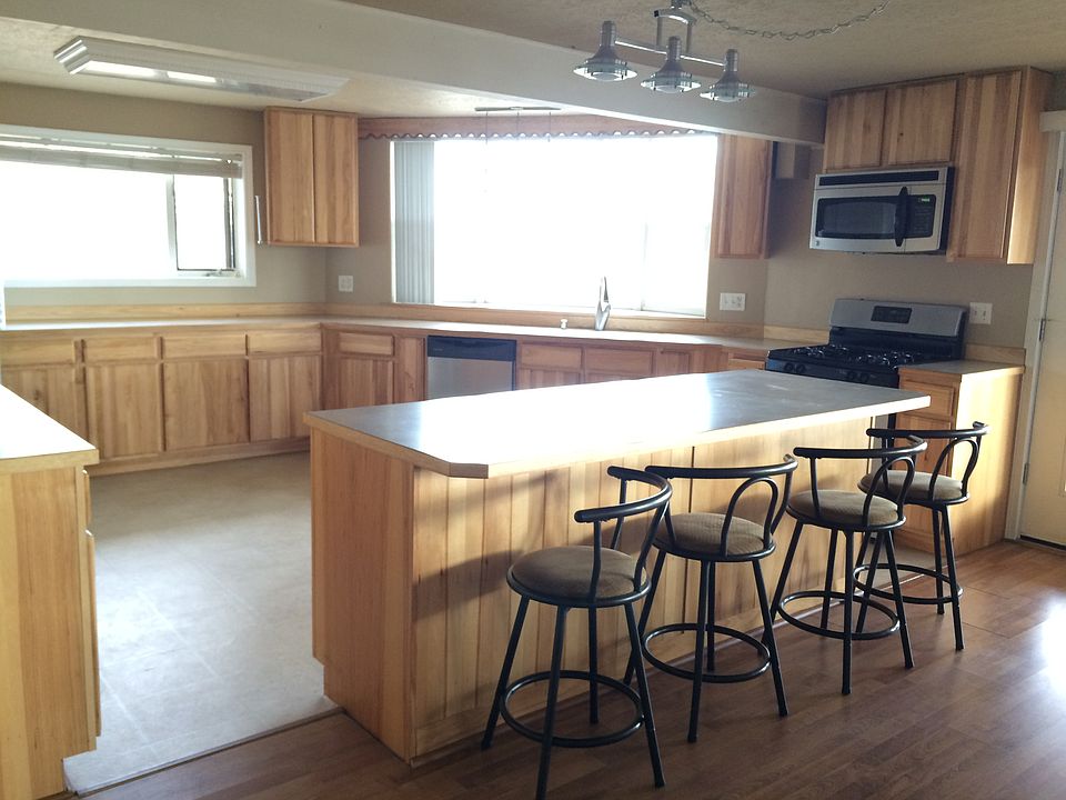 Spacious kitchen, stainless steel appliances, plenty of cabinet space, well-lit, large eating area.