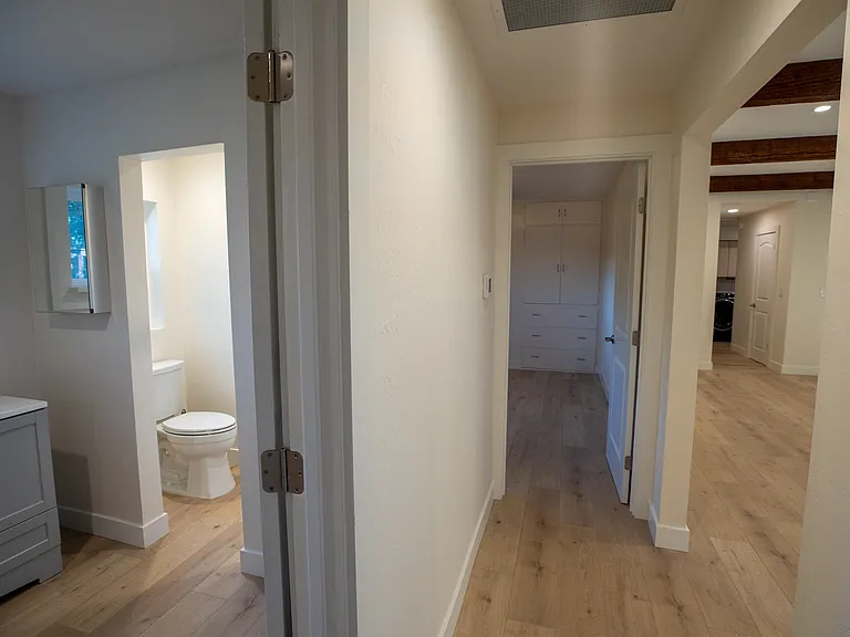 Hallway right off the large living room / den allows access to a large bedroom with closet and build it drawer/cabinets. Large new bathroom to the left with access to the hall and additional bedroom.