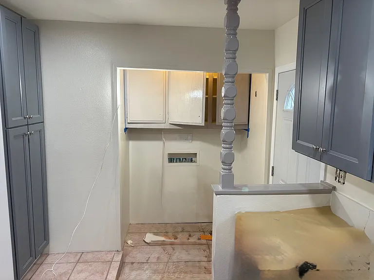 Into the kitchen, towards the back door on the right (barely visible). Straight is the washer dryer hookups. On the left pantry cabinet stands next to refrigerator area (not pictured)