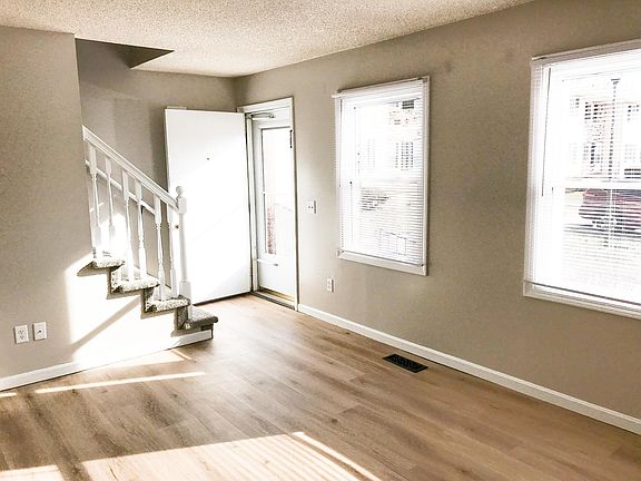 Living room with coat closet and stairwell to 2nd floor