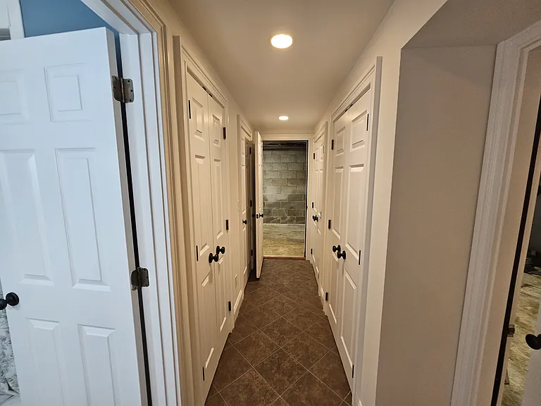 Basement Hallway - View 1.
Full bathroom on the left, lots of storage area in the middle and access door to the mechanical room at the end and in the right.