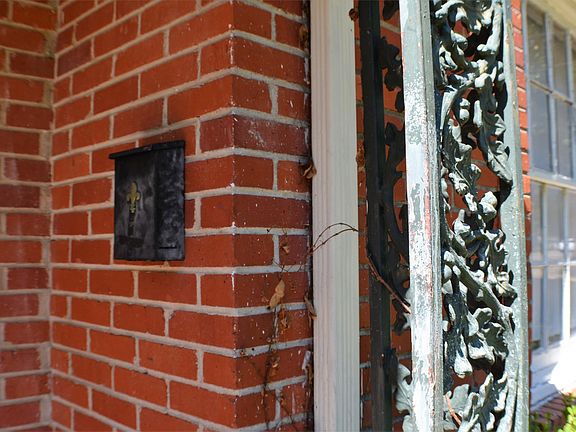 Brick home with mailbox at front door.