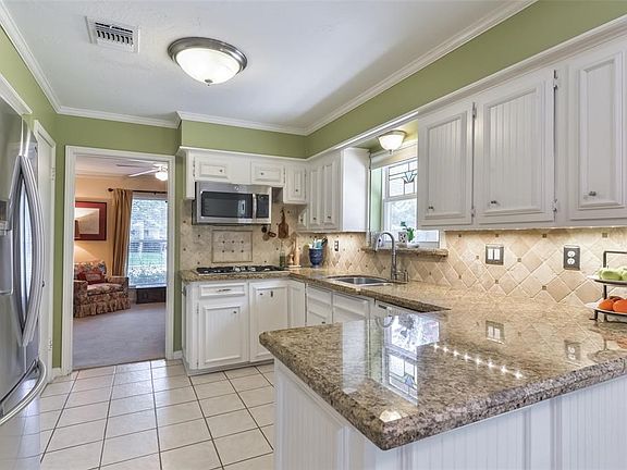 Kitchen has stainless steel appliances, granite counter tops, double ovens,  and a gas stove top.