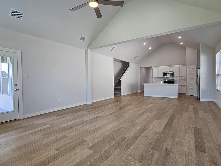 The expansive open-concept living area flooded with natural light from large windows.