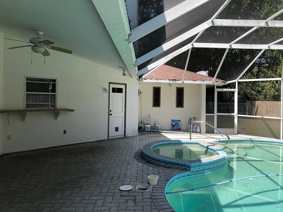Kitchen window pass-through, cabana bathroom door, paver screened patio and swimming pool