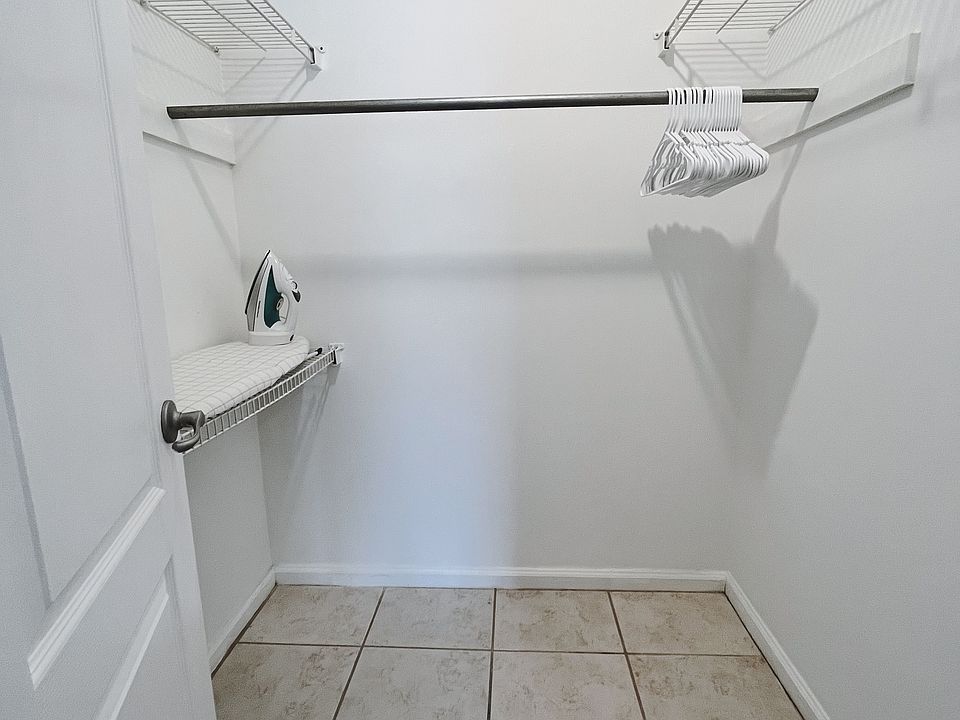 Master bedroom walk-in closet with iron and ironing board