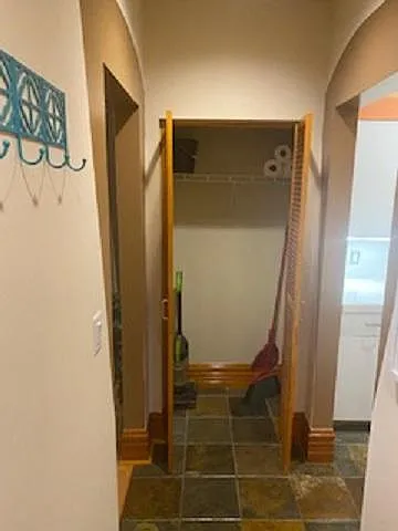 Hallway between kitchen, bedroom and bath with storage closet