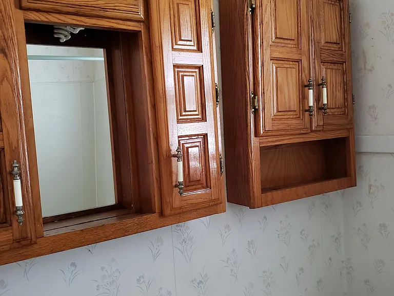 View of bathroom over head cabinets/ vanity with light fixture, sink and toilet