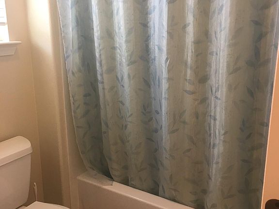 shower/tub combo with tile flooring