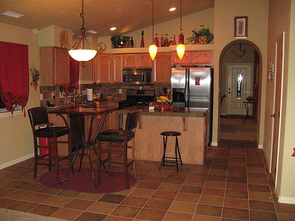 Beautiful kitchen with granite tile countertops and decorative accent lighting