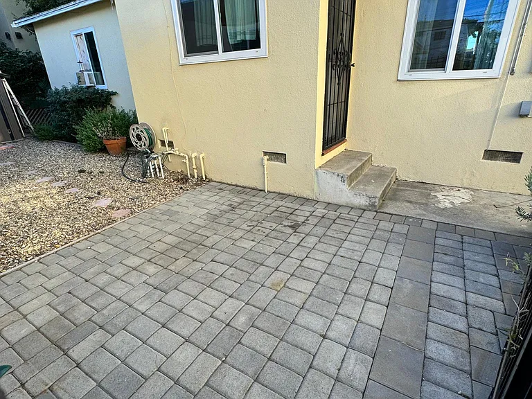 Private, gated, outdoor patio with seating area, garden, and space for outdoor storage