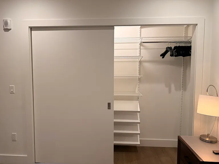 Huge closet with Elfa Container Store shelves for shoes, and area for hanging longer coats, dresses, and suits.