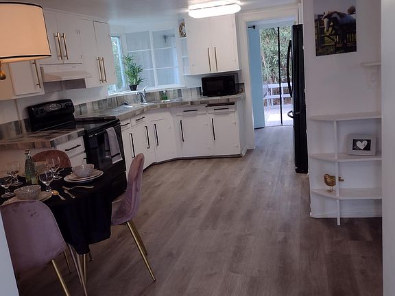 Looking through the kitchen into laundry room and then back yard