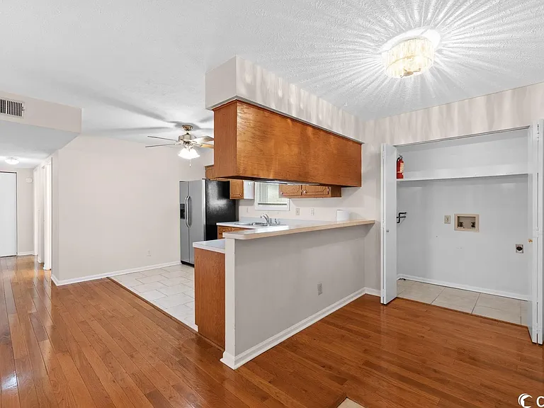 Living Room with view of Kitchen with Laundry Area and Hallway