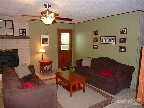 Large family room with brick fireplace and woodburning insert.