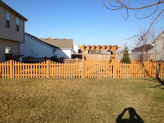 Lovely pergola styled arbor over the gate.