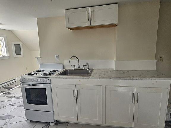 Partial view of the up-dated kitchen which features new electric range and refrigerator