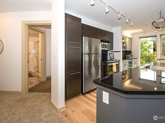 This view is toward the entrance to the primary suite on the left and a great view of the kitchen.>